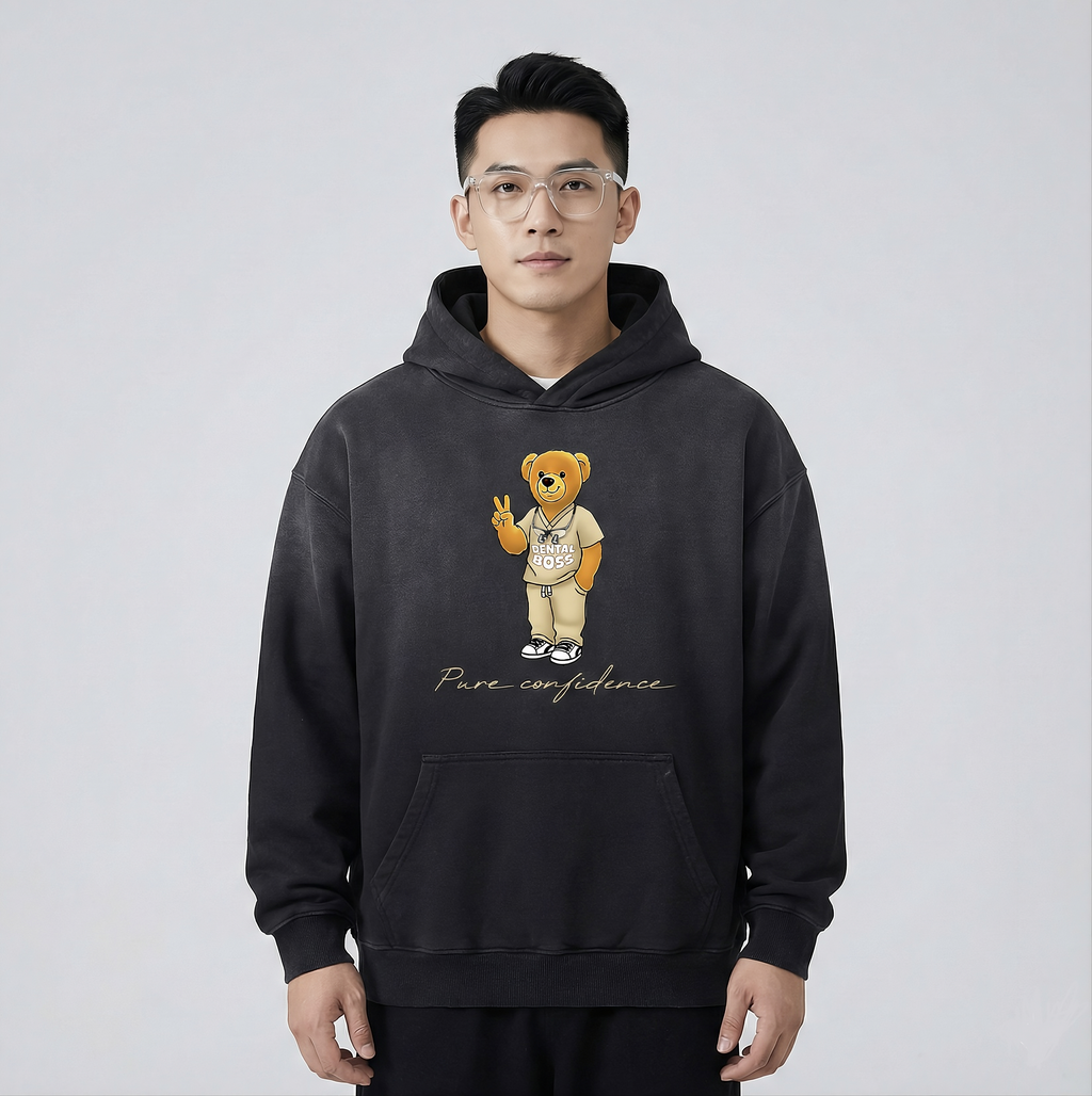 Person wearing a black hoodie with a teddy bear graphic and 'Pure confidence' text on a light gray background